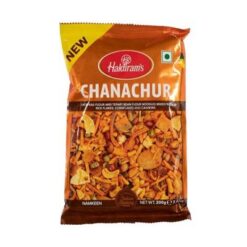 HALDIRAM'S Chanachur Snacks Chana Chur er en indisk snackblanding som består av en blanding av krydrede tørkede ingredienser som stekte linser, peanøtter, kikertmel, mais, kikerter, ris i flak, stekt løk, etc.